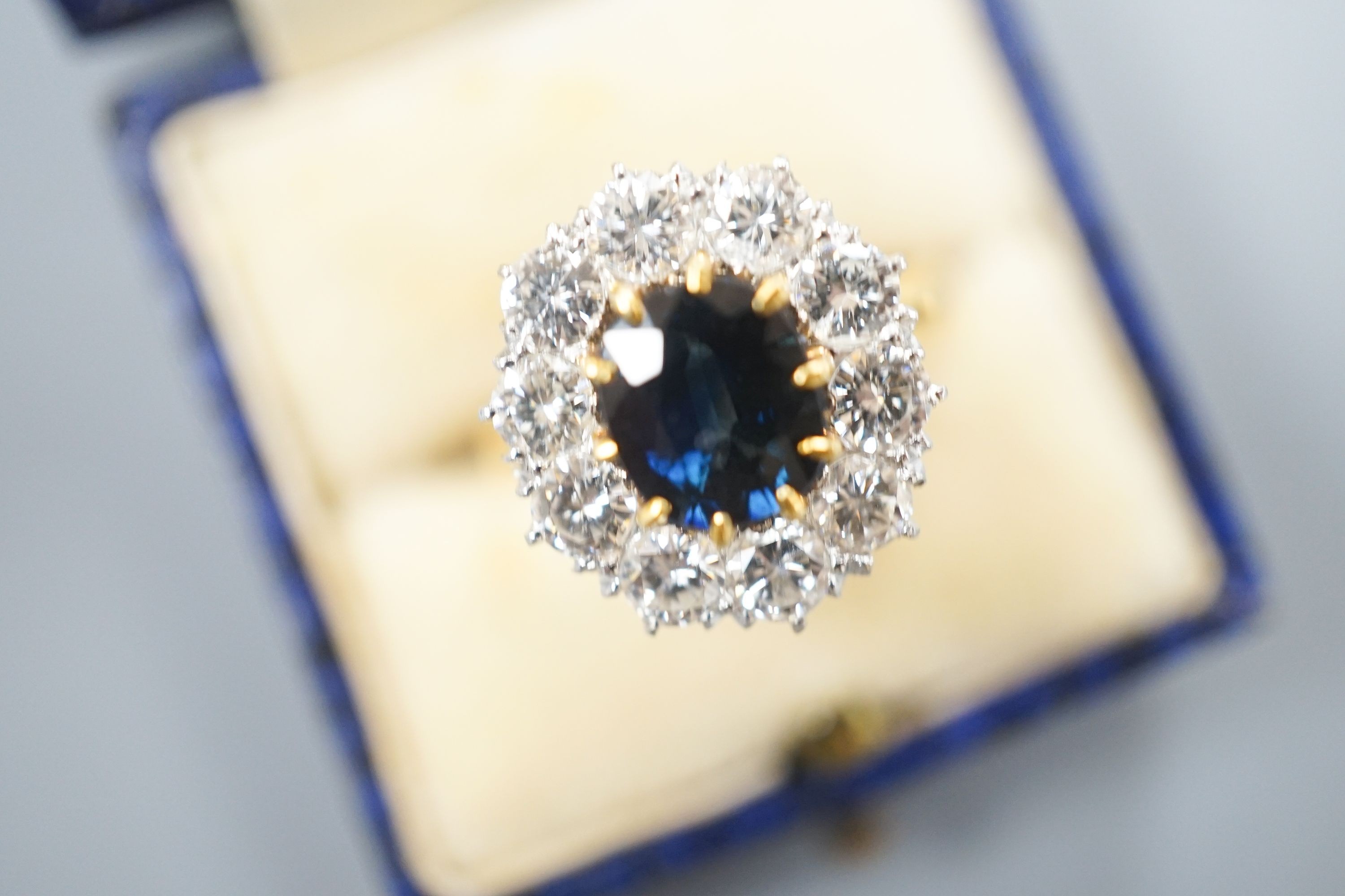 A modern 18ct gold, sapphire and diamond set oval cluster ring, size P/Q, gross weight 6.2 grams.
